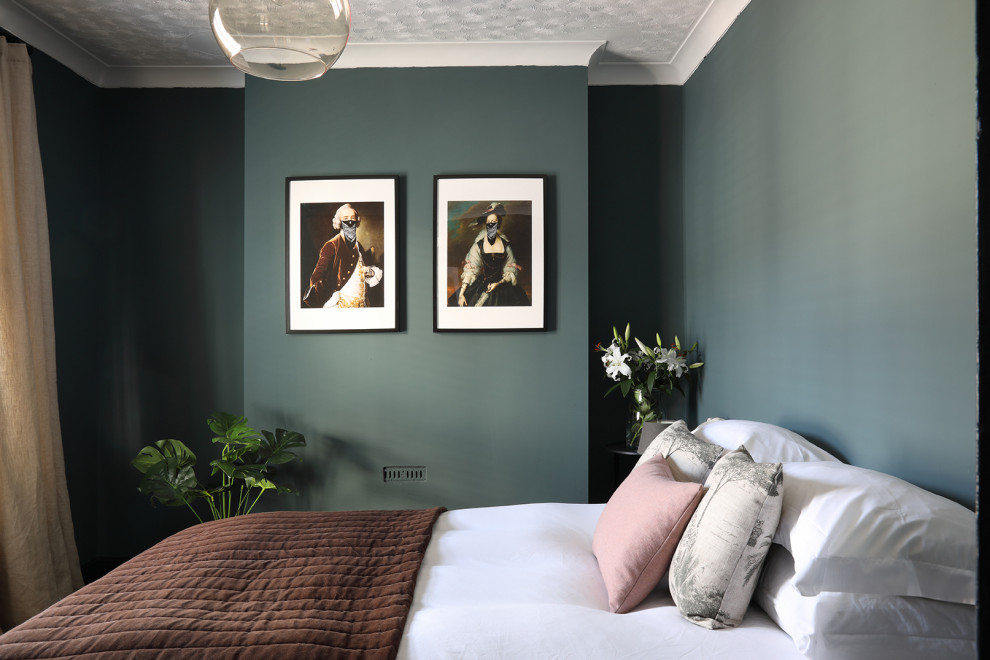 Modelo de dormitorio principal de tamaño medio sin chimenea con paredes verdes, suelo de madera en tonos medios y suelo marrón