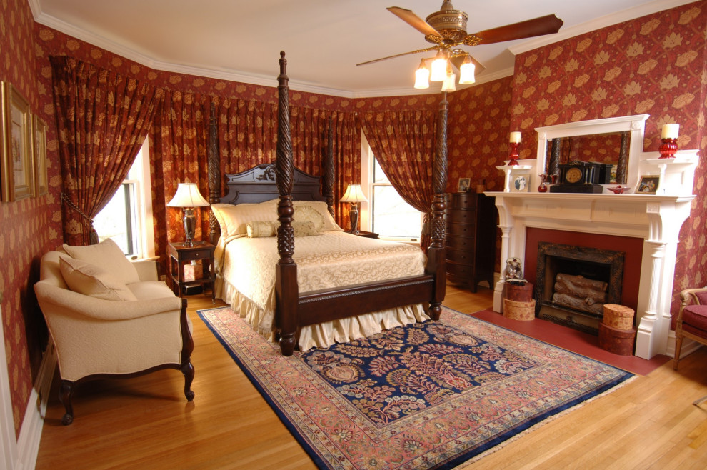 Источник вдохновения для домашнего уюта: хозяйская спальня среднего размера в викторианском стиле с красными стенами, светлым паркетным полом, стандартным камином и фасадом камина из дерева