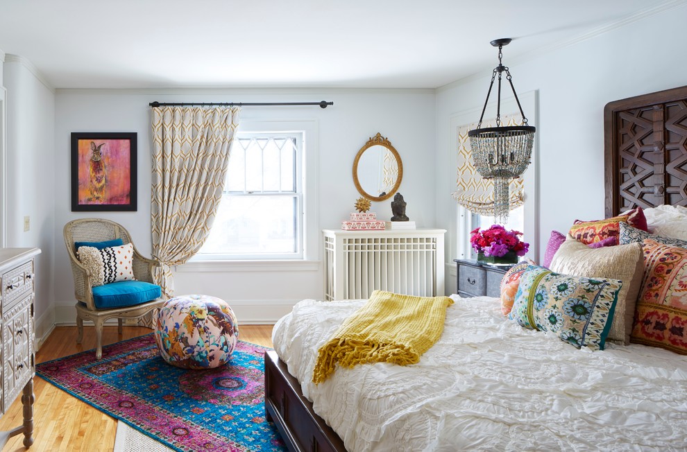 Example of an eclectic master medium tone wood floor bedroom design in Minneapolis with white walls