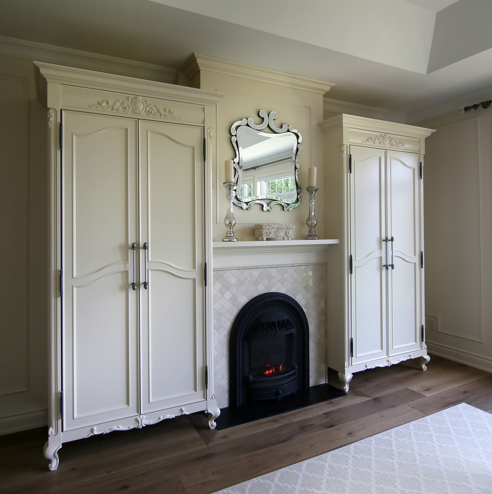 Imagen de dormitorio tradicional de tamaño medio con paredes beige, suelo de madera en tonos medios, todas las chimeneas y marco de chimenea de baldosas y/o azulejos