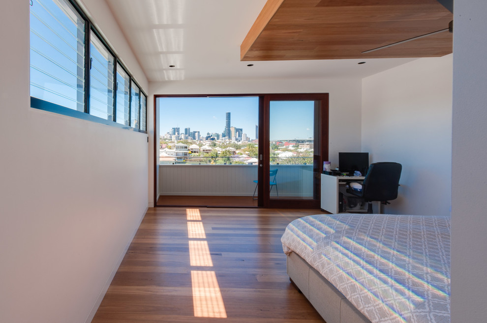Großes Modernes Hauptschlafzimmer ohne Kamin mit weißer Wandfarbe und hellem Holzboden in Brisbane