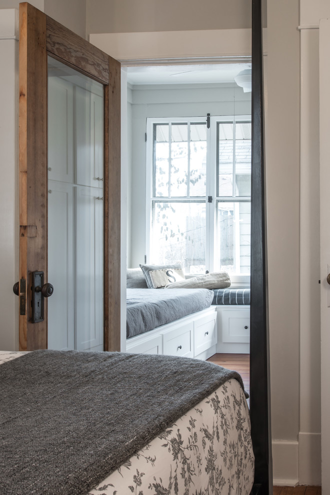 Esempio di una piccola camera degli ospiti eclettica con pareti grigie e pavimento in legno massello medio
