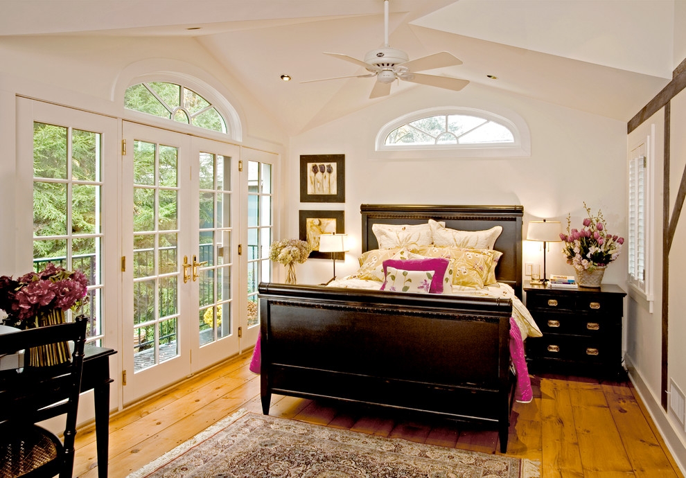 Imagen de dormitorio principal clásico grande con paredes blancas y suelo de madera en tonos medios
