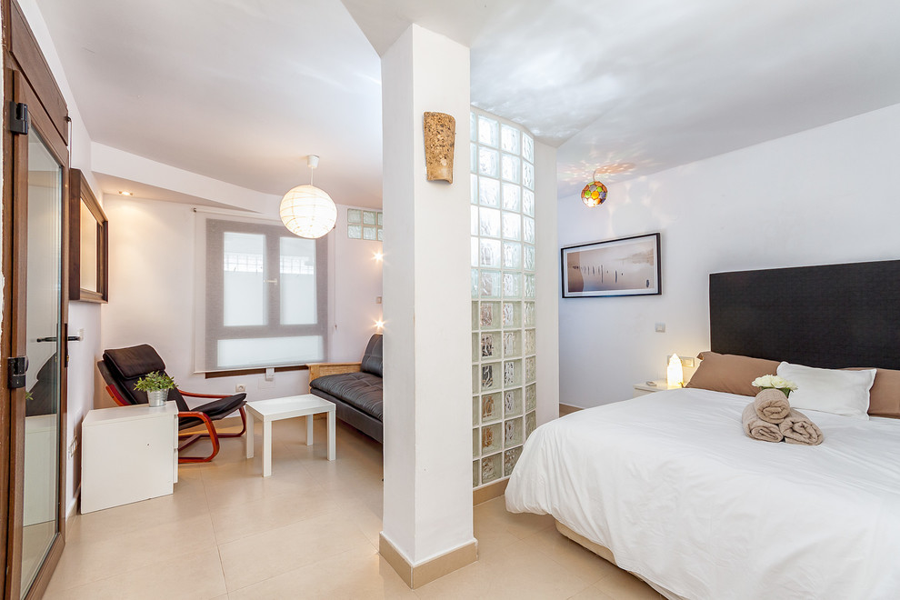 Ejemplo de dormitorio tipo loft mediterráneo de tamaño medio sin chimenea con paredes blancas y suelo de baldosas de cerámica