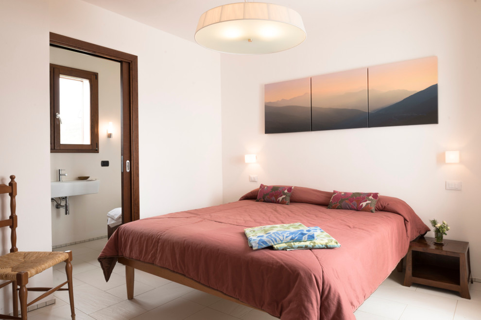 Example of a small beach style guest ceramic tile bedroom design in London with white walls