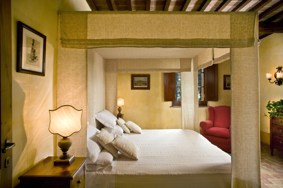 Стильный дизайн: большая хозяйская спальня в классическом стиле с желтыми стенами и кирпичным полом - последний тренд