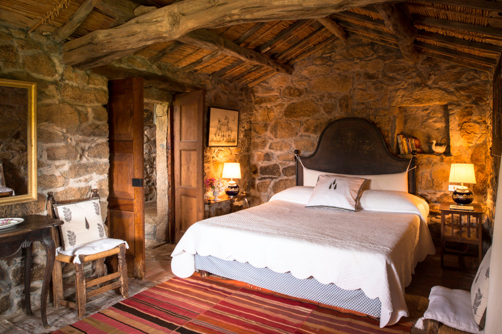 Medium sized rustic master bedroom in London with brick flooring and brown walls.