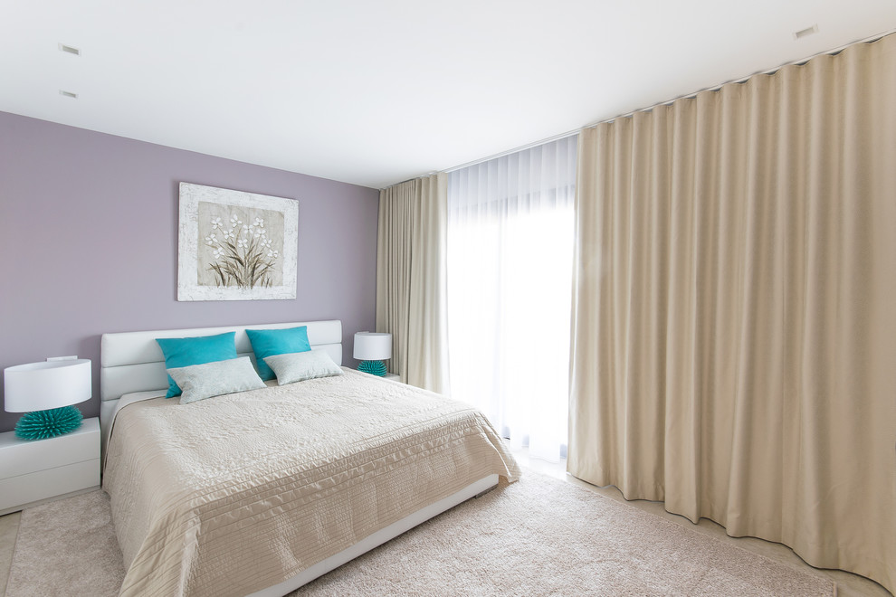 マヨルカ島にある広いモダンスタイルのおしゃれな客用寝室 (紫の壁、大理石の床) のインテリア
