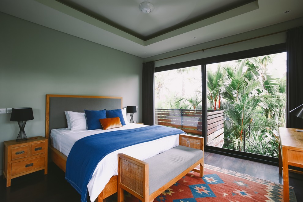 Cette image montre une chambre design avec un mur gris, parquet foncé et un sol marron.