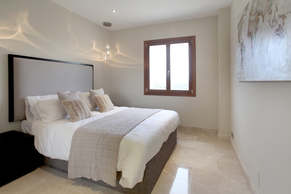 Immagine di una camera degli ospiti mediterranea di medie dimensioni con pareti bianche e pavimento in marmo