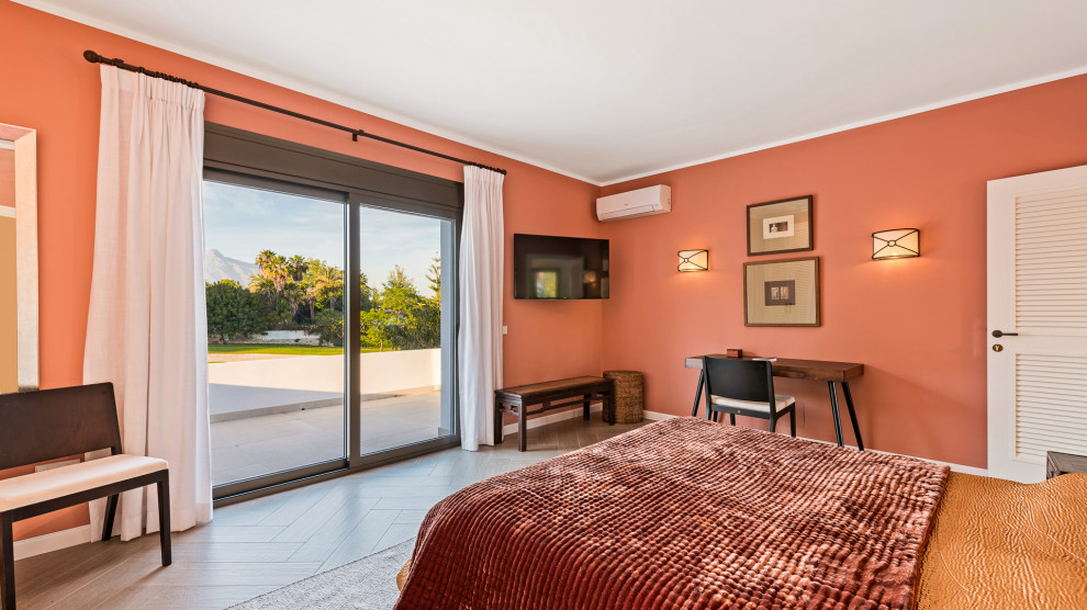 Diseño de dormitorio principal clásico grande con parades naranjas, suelo de baldosas de cerámica y suelo beige