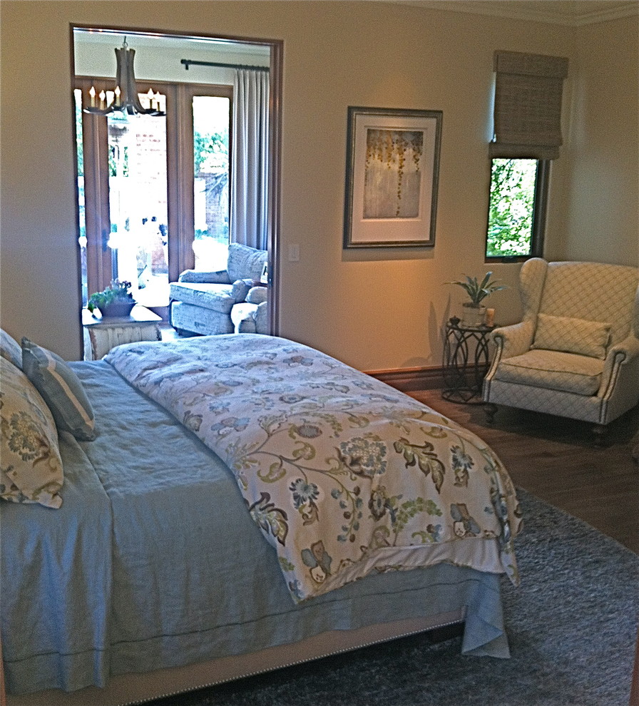 This is an example of a large mediterranean master bedroom in Orange County with beige walls and medium hardwood flooring.
