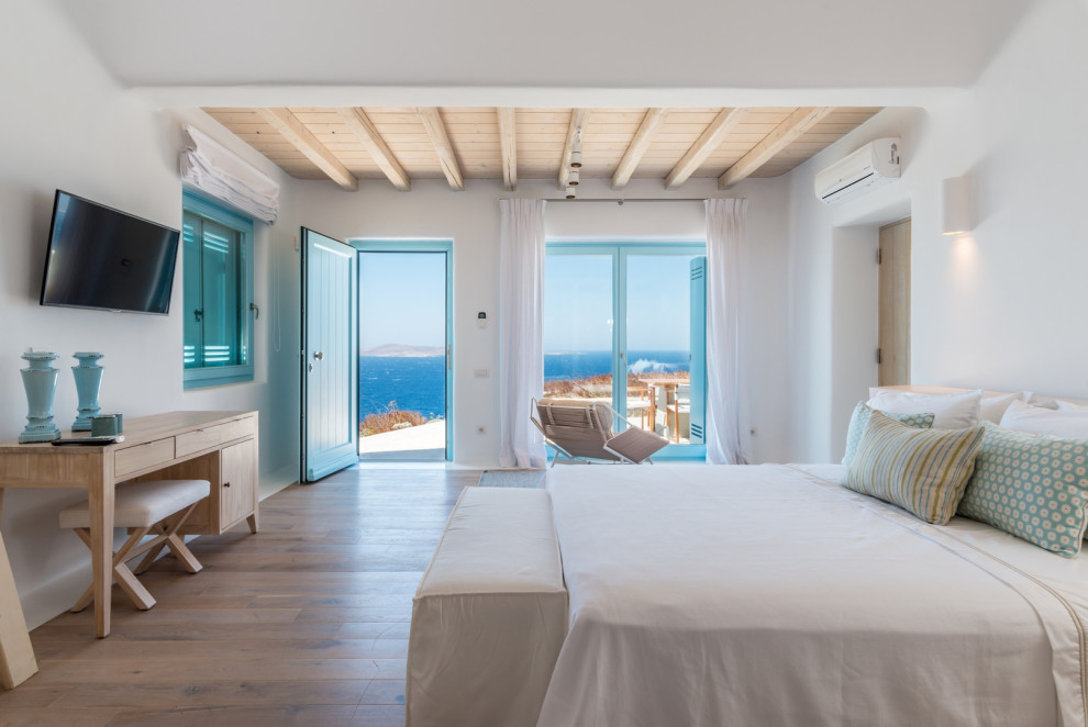他の地域にあるビーチスタイルのおしゃれな寝室 (白い壁、淡色無垢フローリング、ベージュの床、表し梁、板張り天井)