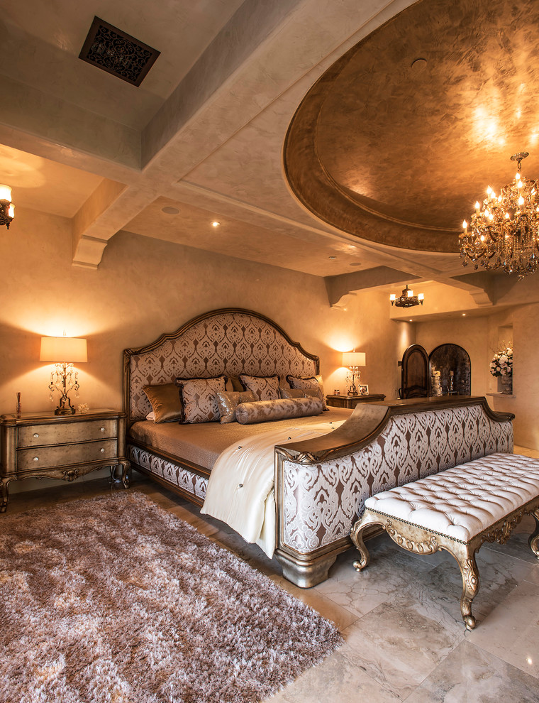 Ejemplo de dormitorio principal mediterráneo grande sin chimenea con paredes beige, marco de chimenea de piedra, suelo beige y suelo de baldosas de porcelana
