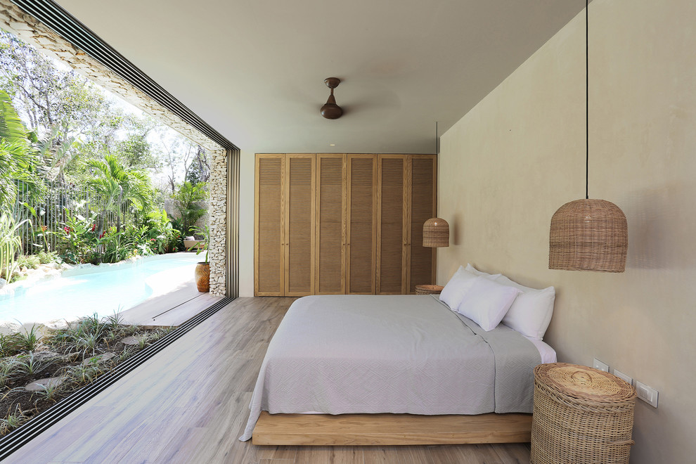 Bedroom - tropical master light wood floor and beige floor bedroom idea in Mexico City with beige walls