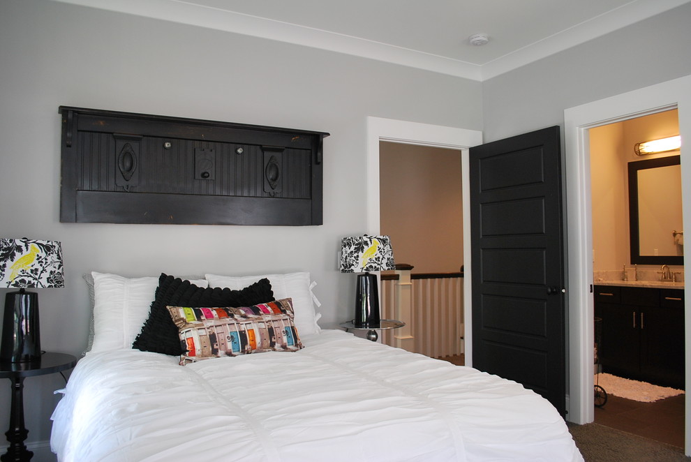 Modelo de dormitorio principal de estilo de casa de campo grande sin chimenea con paredes grises, suelo de madera en tonos medios y suelo marrón