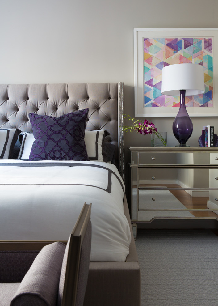 Traditional grey and purple bedroom in New York with grey walls and carpet.