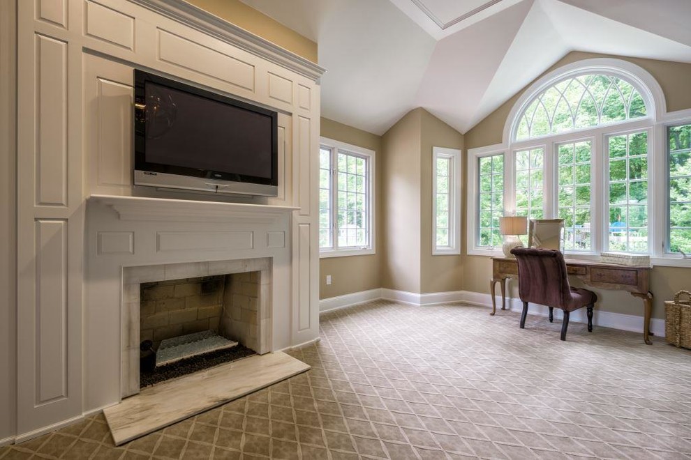 This is an example of a large traditional master bedroom in Philadelphia with beige walls, carpet, a standard fireplace and a stone fireplace surround.