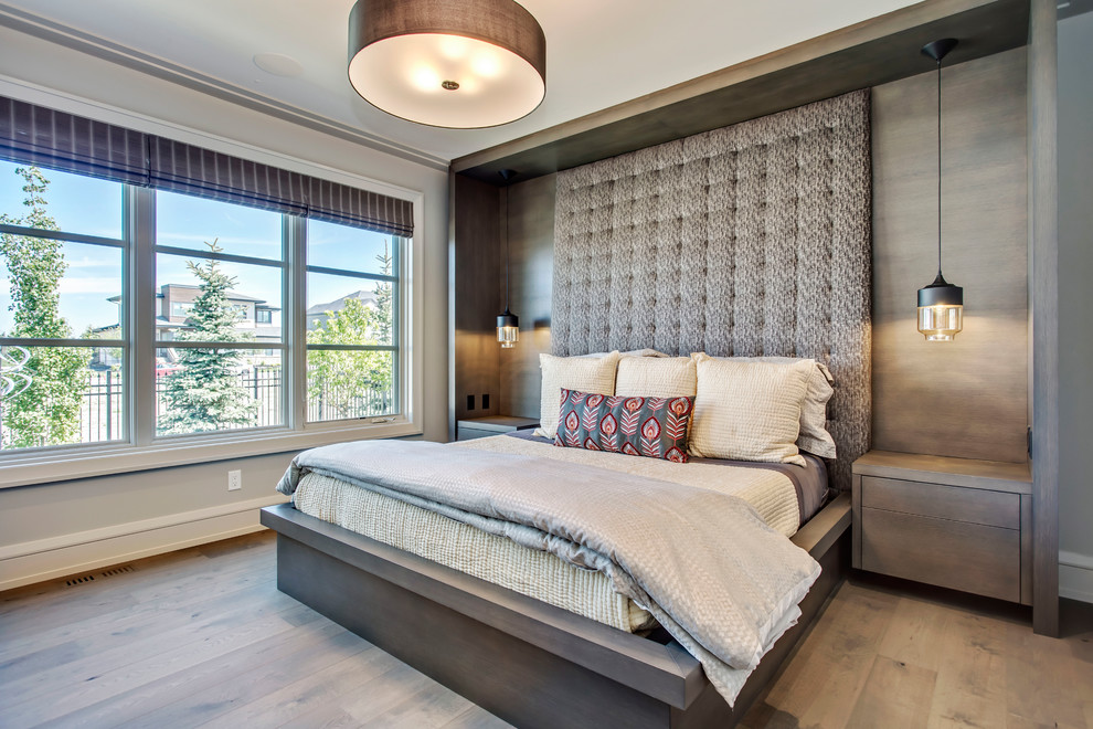 Inspiration for a contemporary master bedroom in Calgary with beige walls, medium hardwood flooring and brown floors.