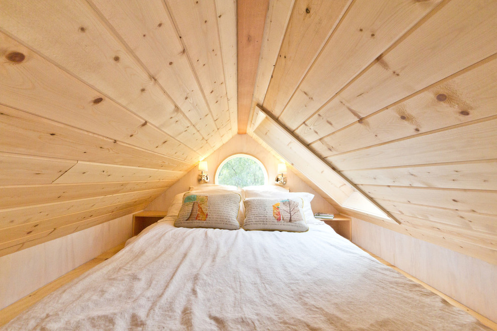 Ispirazione per una piccola camera da letto stile loft contemporanea con pareti bianche, pavimento in legno massello medio e nessun camino