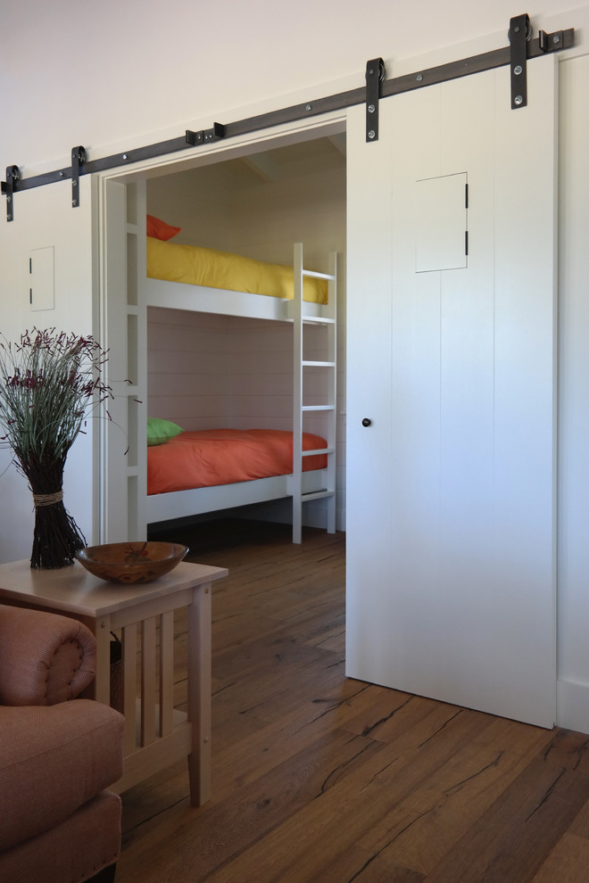 Imagen de habitación de invitados campestre pequeña con paredes blancas y suelo de madera en tonos medios