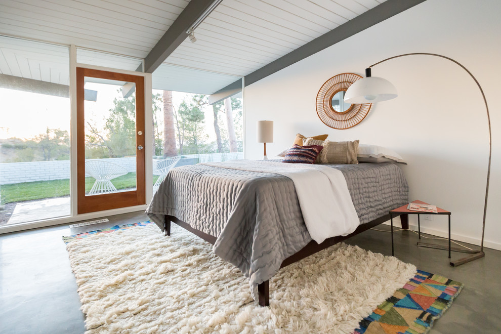 На фото: спальня в современном стиле с белыми стенами и бетонным полом