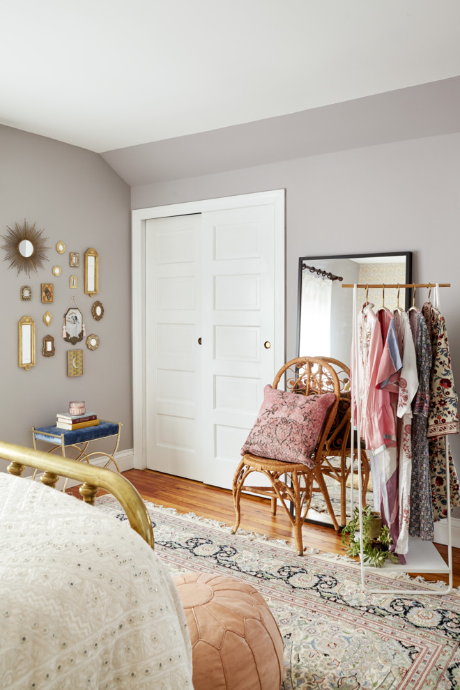 Foto de dormitorio principal bohemio de tamaño medio sin chimenea con paredes púrpuras, suelo de madera en tonos medios y suelo marrón
