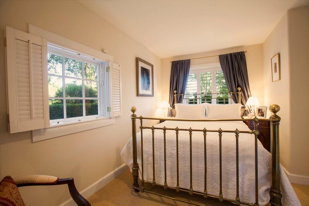 Ejemplo de habitación de invitados clásica pequeña con paredes beige y moqueta