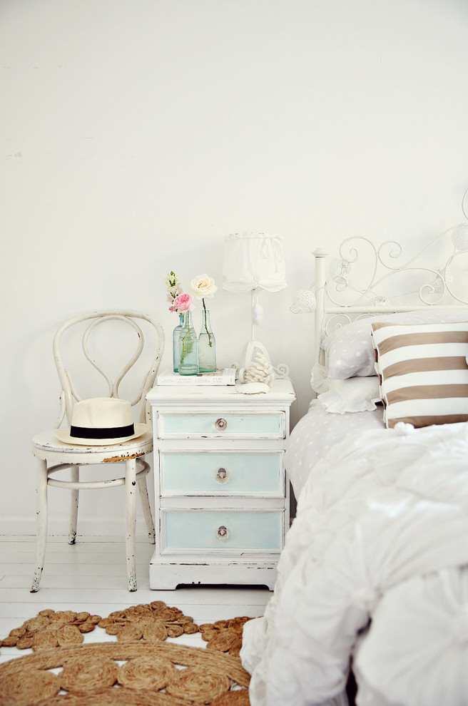 Cottage chic light wood floor and white floor bedroom photo in Sydney with white walls