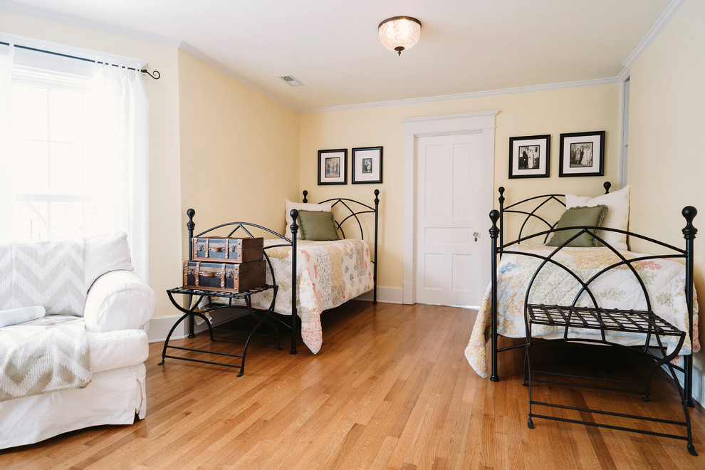 Cette photo montre une chambre d'amis chic avec un mur beige et un sol en bois brun.