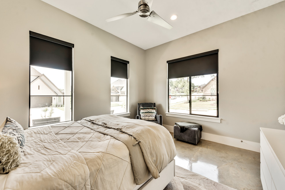 Modelo de habitación de invitados campestre con paredes beige, suelo de cemento y suelo beige