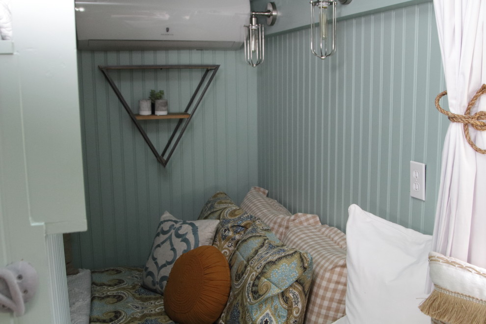 Kleines Landhaus Hauptschlafzimmer mit grüner Wandfarbe und Laminat in Sonstige