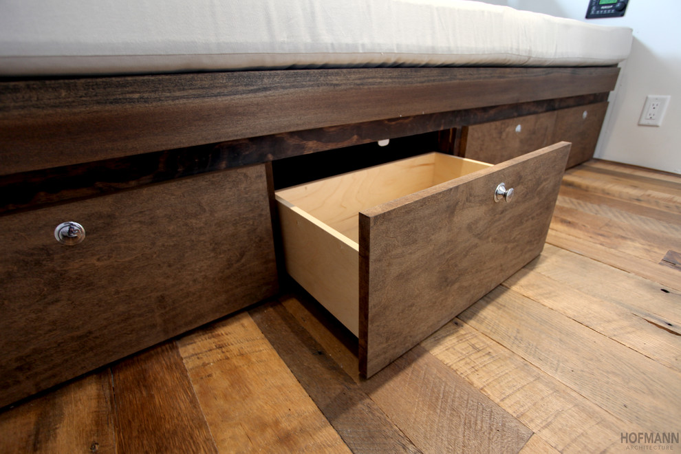 Modelo de dormitorio rústico pequeño con paredes blancas y suelo de madera oscura