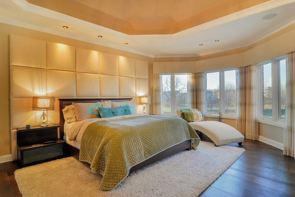 Aménagement d'une chambre classique avec un mur beige et parquet foncé.