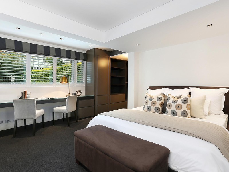 Ejemplo de dormitorio principal actual de tamaño medio con paredes blancas, moqueta y suelo marrón