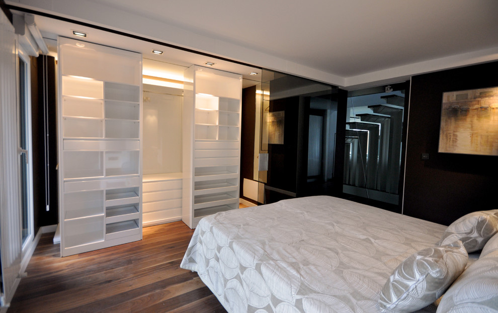 Стильный дизайн: хозяйская спальня среднего размера в стиле модернизм с черными стенами и темным паркетным полом без камина - последний тренд