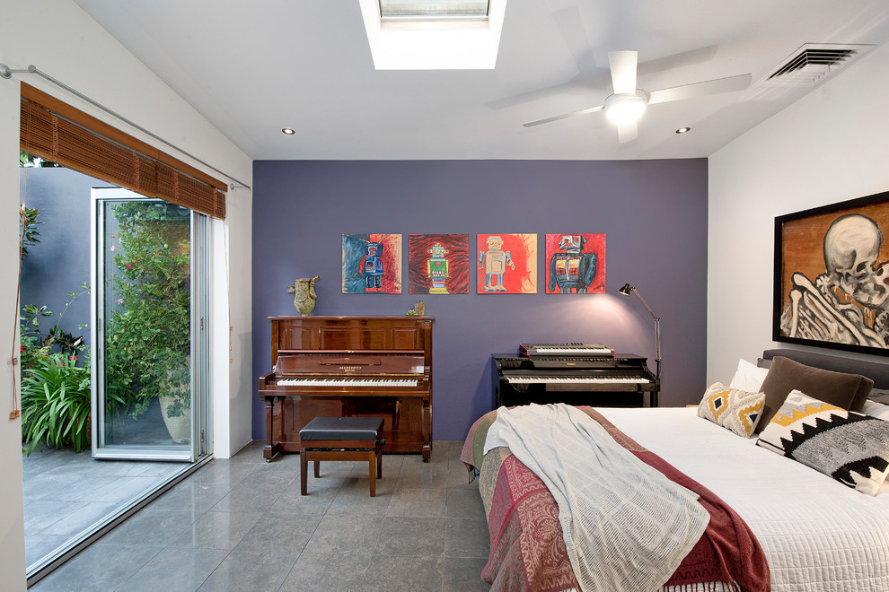 Ispirazione per una camera degli ospiti boho chic con pareti viola, pavimento grigio e pavimento in gres porcellanato