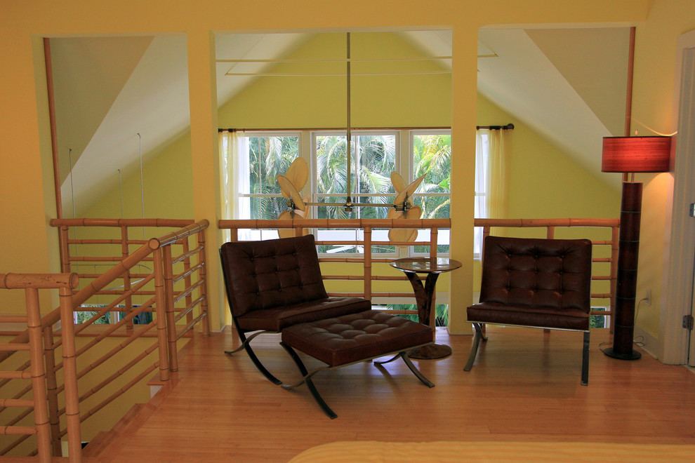 Diseño de dormitorio tipo loft contemporáneo de tamaño medio con paredes amarillas y suelo de bambú