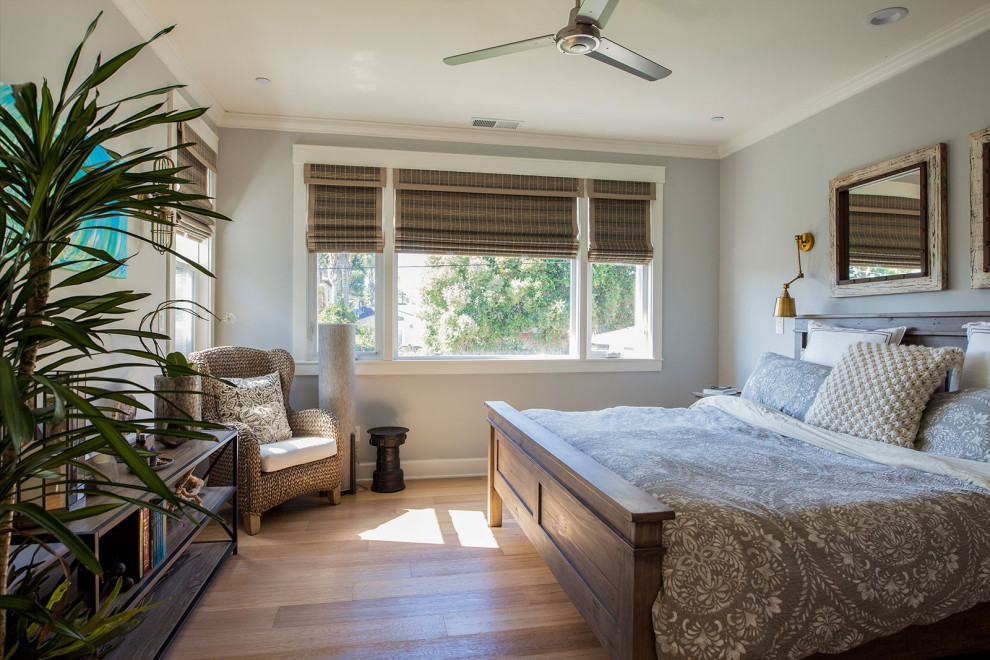Ejemplo de dormitorio principal marinero grande con paredes grises, suelo de madera en tonos medios y suelo beige