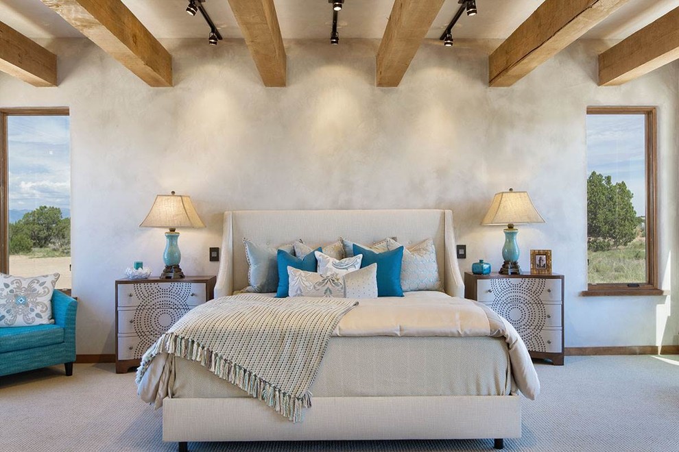 Modelo de dormitorio principal de estilo americano grande con paredes beige, moqueta, chimenea de esquina y marco de chimenea de piedra