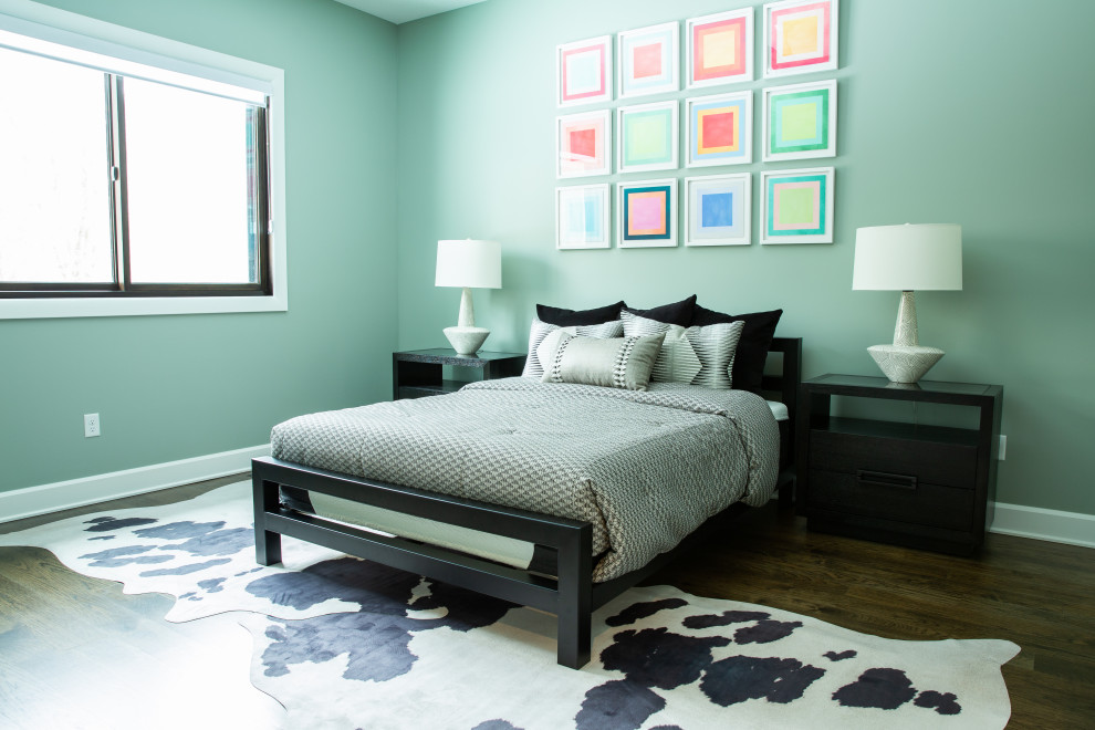 Imagen de dormitorio actual con paredes verdes, suelo de madera oscura y suelo marrón