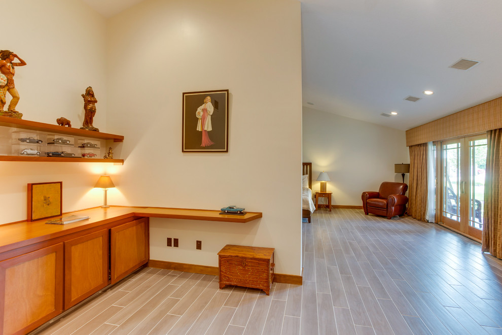 ヒューストンにある広いトラディショナルスタイルのおしゃれな主寝室 (ベージュの壁、磁器タイルの床、暖炉なし、ベージュの床)