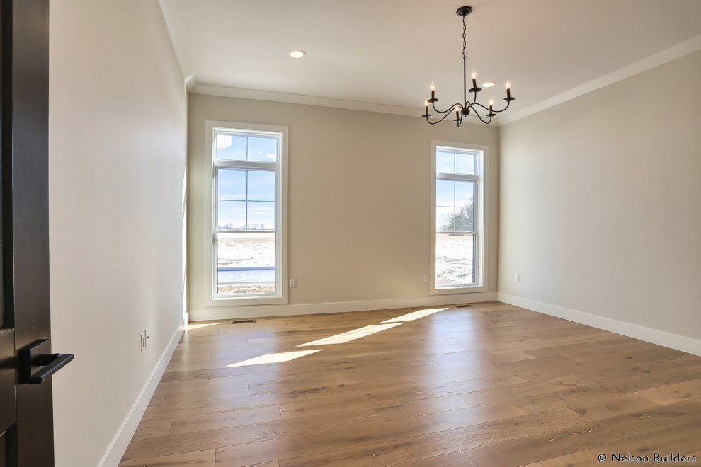 Example of a mid-sized farmhouse master light wood floor and brown floor bedroom design in Chicago with beige walls