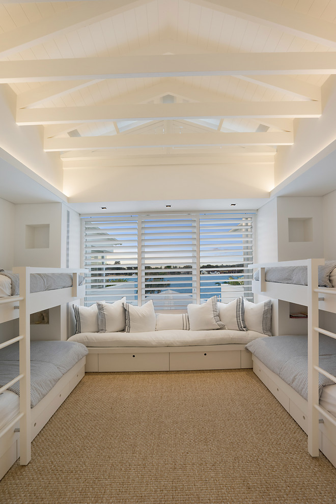 Modelo de habitación de invitados marinera con paredes blancas, moqueta y suelo beige