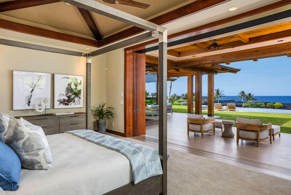Example of an island style master carpeted and beige floor bedroom design in Hawaii with beige walls
