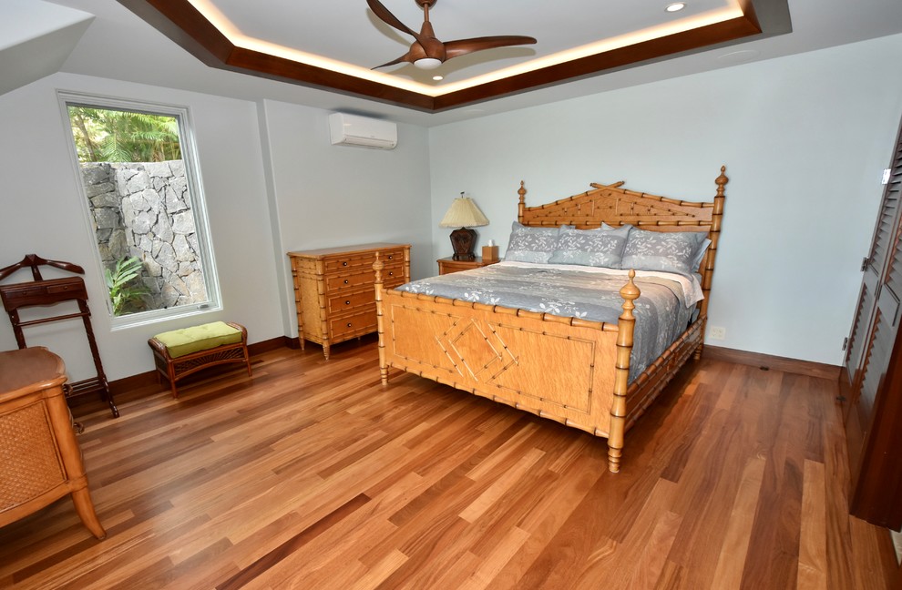 Ispirazione per una camera degli ospiti tropicale di medie dimensioni con pareti beige, pavimento in legno massello medio e nessun camino