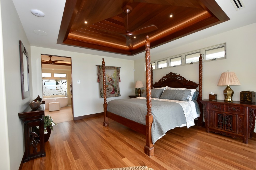 Mid-sized island style master medium tone wood floor bedroom photo in Hawaii with beige walls and no fireplace