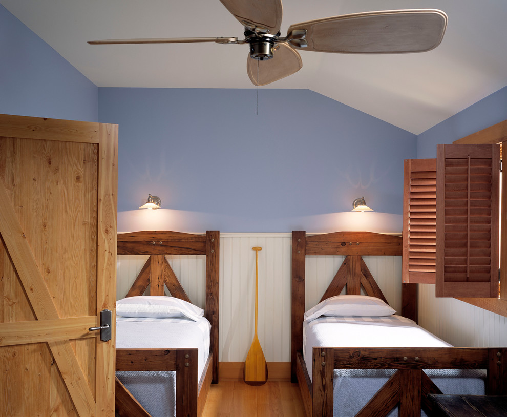 他の地域にある中くらいなラスティックスタイルのおしゃれな客用寝室 (青い壁、淡色無垢フローリング、暖炉なし、茶色い床) のインテリア
