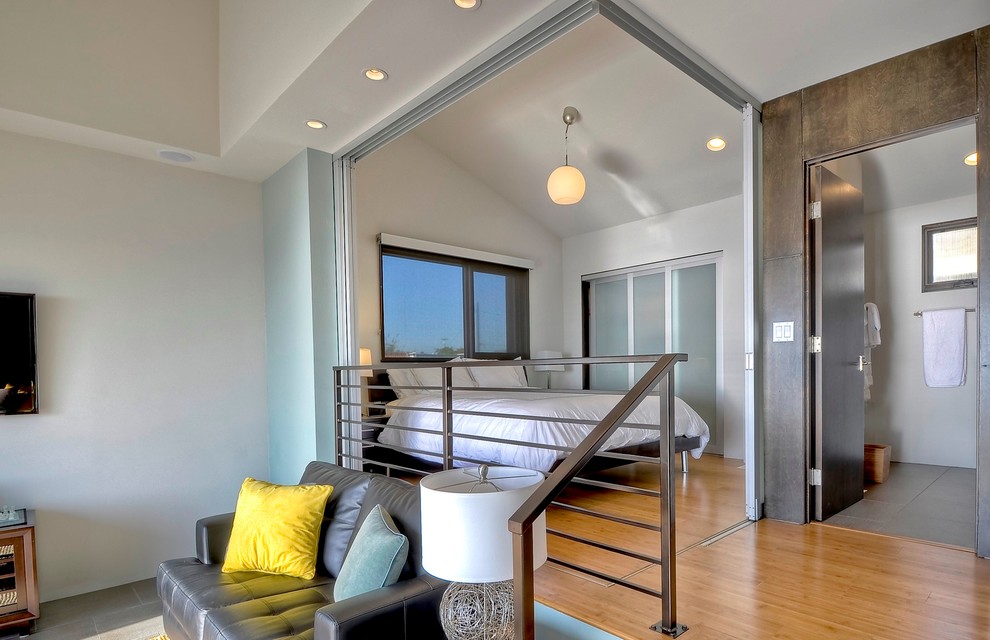 Inspiration for a contemporary loft-style medium tone wood floor bedroom remodel in Vancouver with white walls