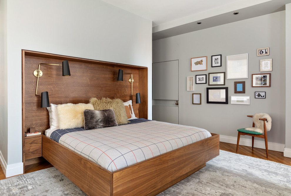 Ejemplo de dormitorio principal retro sin chimenea con paredes grises y suelo de madera en tonos medios